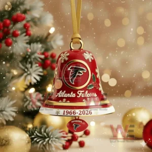 A red Atlanta Falcons anniversary bell ornament with gold accents hanging before a decorated Christmas tree!
