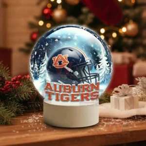 Auburn Tigers Christmas Snow Globe Decoration Led Night Light 4 A snow globe with a dark blue team helmet sits on a wooden table surrounded by holiday decorations!