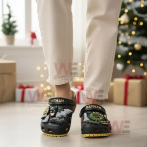 Person wearing Batman themed clogs indoors with festive decor in background!