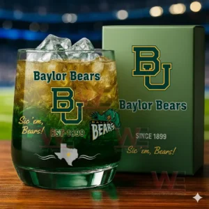 A close view of a Baylor Bears whiskey glass filled with an amber drink and ice displayed beside its green branded box in a stadium inspired setting!
