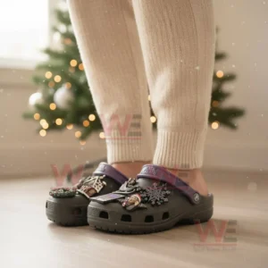 A person wearing black clogs with gothic charms in a holiday setting with a Christmas tree behind them!