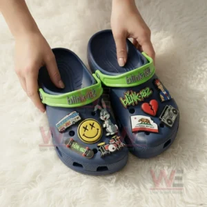 Blink 182 Crocs Crocband Clogs With Charms 4 Person wearing navy clogs with white socks featuring green blink one eight two straps and colorful music themed charms.