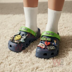 Blink 182 Crocs Crocband Clogs With Charms 5 Person wearing navy clogs with white socks featuring green blink one eight two straps and colorful music themed charms.