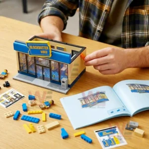 Blockbuster Video Classic Video Store Building Block Set 6 Hands assembling a small building block video store with pieces spread on a table and an open instruction guide nearby!