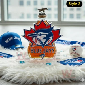 A maple leaf shaped bottle with a central blue jay emblem displayed on a soft rug with baseball accessories around it!