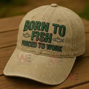Beige fishing cap with embroidered text and fish icons resting on a wooden surface in natural light!