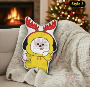 Yellow christmas character pillow with antlers on a couch in a warm holiday decorated room!