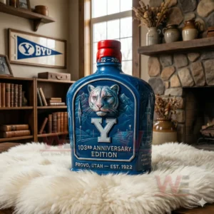 BYU 103th Anniversary Edition Whiskey Bottle 6 A detailed blue bottle with a cougar illustration standing on a fluffy rug in a room decorated with wood shelves and pottery.