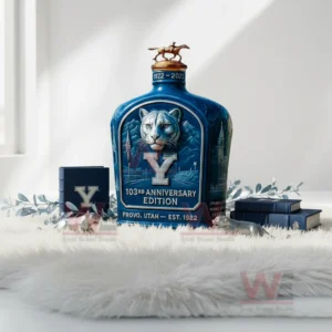 BYU 103th Anniversary Edition Whiskey Bottle 7 A blue bottle featuring a cougar illustration and rider statue topper positioned on a soft white surface with decorative items.