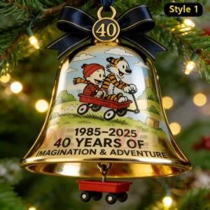 A close up view of a gold holiday bell ornament showing two characters riding in a wagon with a small red wagon charm suspended below!