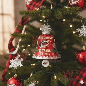 A red Carolina Hurricanes holiday bell ornament with team details hanging on a Christmas tree!