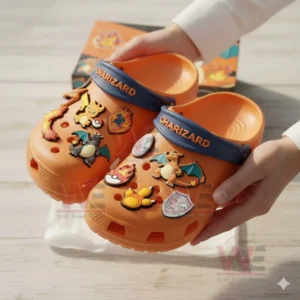 Orange Charizard themed clogs decorated with fire and character charms held by two hands!