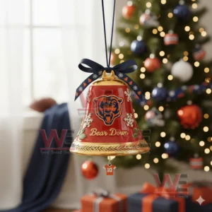 A red Chicago Bears holiday bell ornament with snowflakes a navy bow and a jersey charm hanging on a Christmas tree!