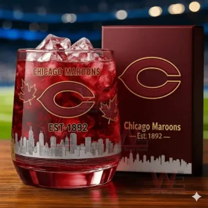A close view of a Chicago Maroons whiskey glass containing a red beverage with ice displayed beside its maroon branded box with skyline artwork!