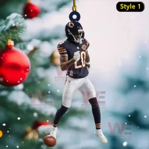 Ornament of a football player in a dark uniform hanging by a string with a snowy Christmas tree background!