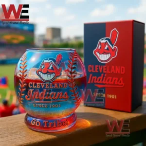 A Cleveland Indians baseball shaped glass with red liquid and team graphics set against a ballpark backdrop!