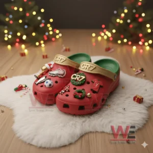 Red CR7 clogs with football and Christmas themed charms placed on a white fur mat with festive decor!