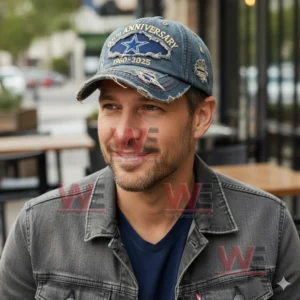 Man wearing a distressed denim baseball cap with 65th Anniversary 1960 2025 embroidery and a star emblem in an outdoor cafe setting.