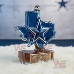 Texas shaped blue bottle with star emblem and horse statue cap displayed on white fur against a star patterned wall.