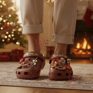 A person wearing red clogs decorated with music and holiday charms in a cozy Christmas setting!