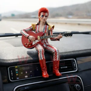 Resin figure of a red haired glam rock musician with face paint holding a red electric guitar sitting on a car dashboard with a highway background!
