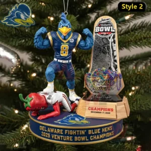 Delaware Blue Hens mascot ornament flexing beside a Ventures Bowl trophy with a small defeated opponent figure on the base and a Christmas tree background.