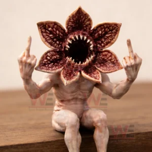 Close up of a monster figurine with a flower like head and sharp teeth raising both hands on a wooden surface!