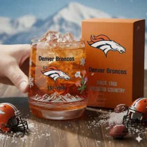 Denver Broncos Broncos Country Whiskey Glass 3 Hand holding a Denver Broncos glass with ice beside an orange box in a mountain themed scene!