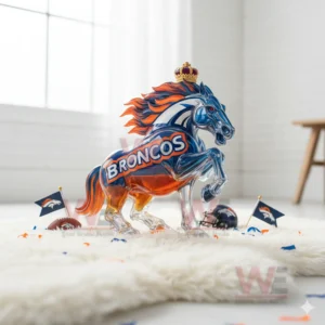 A clear glass horse in Broncos colors stands on a white surface with tiny flags and helmets nearby!