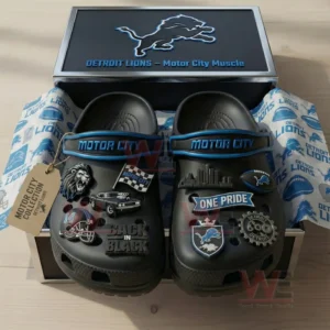 Black clogs decorated with Detroit Lions themed charms arranged inside an open box on branded wrapping paper!