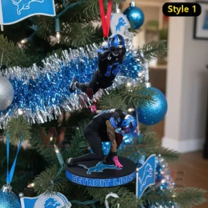 The image shows two Detroit Lions football player ornaments hanging from a Christmas tree surrounded by team themed decorations.