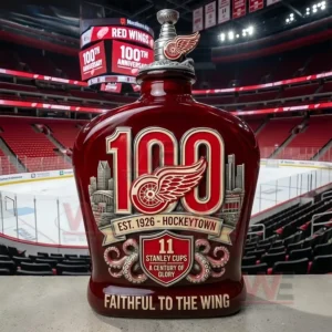 Detroit Red Wings 100Th Anniversary Hockeytown Stanley Cup Legacy Whiskey Bottle 3 Red commemorative hockey bottle standing in an indoor ice arena with seats scoreboard and rink visible behind it!