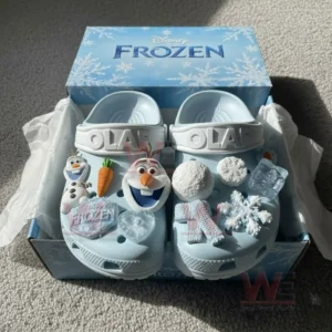 Disney Frozen light blue clogs with Olaf themed charms resting inside a decorative Frozen box!