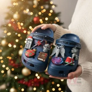 Blue themed clogs with various charms held in front of a Christmas tree!