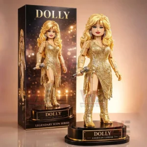 Gold dressed Dolly collectible figure with blonde hair holding a microphone on a black display base shown next to a matching Dolly collector box!