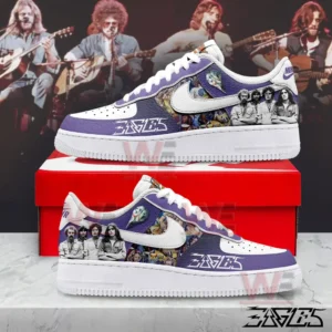 Purple and white Eagles themed sneakers shown in side view on a red shoebox with a live concert background.