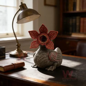Monster duck figure on a desk with a lamp and books in a warm indoor setting!