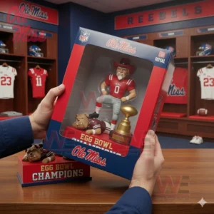 Hands holding an Ole Miss Rebels Egg Bowl Champions collectible figure box with the figure trophy and mascot visible through the window.