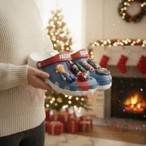 Blue and red clogs decorated with themed charms held near a Christmas tree!