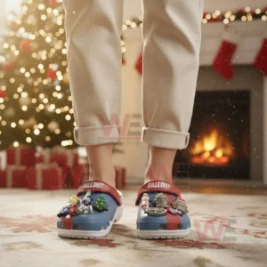 A person wearing blue and red themed clogs with charms in a holiday decorated room!