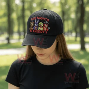 Black baseball cap with embroidered game characters worn by a person in a park setting!