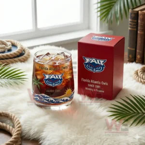 Florida Atlantic Owls whiskey glass with ice and dark drink next to a red branded box on a soft decorative surface!