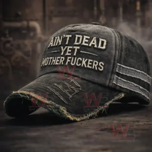 A distressed black denim baseball cap with frayed brim and white embroidered text on a dark surface with an industrial background!