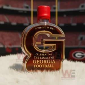 A G shaped Georgia football legacy bottle with a red cap placed on a white rug in front of a stadium background!