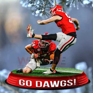 A Georgia Bulldogs kicker and holder positioned on a miniature football field ornament with a team slogan at the bottom!