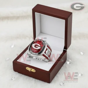 Georgia Bulldogs ring in an open wooden display box with white interior featuring a red gemstone style top letter G team wording and small decorative crystals on a soft white background!