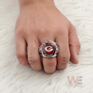 Hand wearing a Georgia Bulldogs ring with a red gemstone style center letter G and team text Georgia Bulldogs Go Dawgs shown on a soft white fur background!