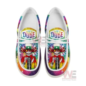 Top view of rainbow tie dye Hey Dude canvas shoes with white laces and skeleton artwork on the front panels set on a white background.