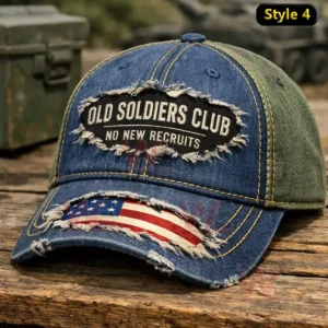 Black distressed baseball cap with Grumpy Old Vet lettering flame design and a camouflage curved brim on a rustic wooden surface.
