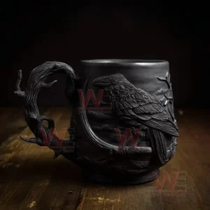 Gothic style mug with raised raven sculpture placed on a wooden surface in low light setting!